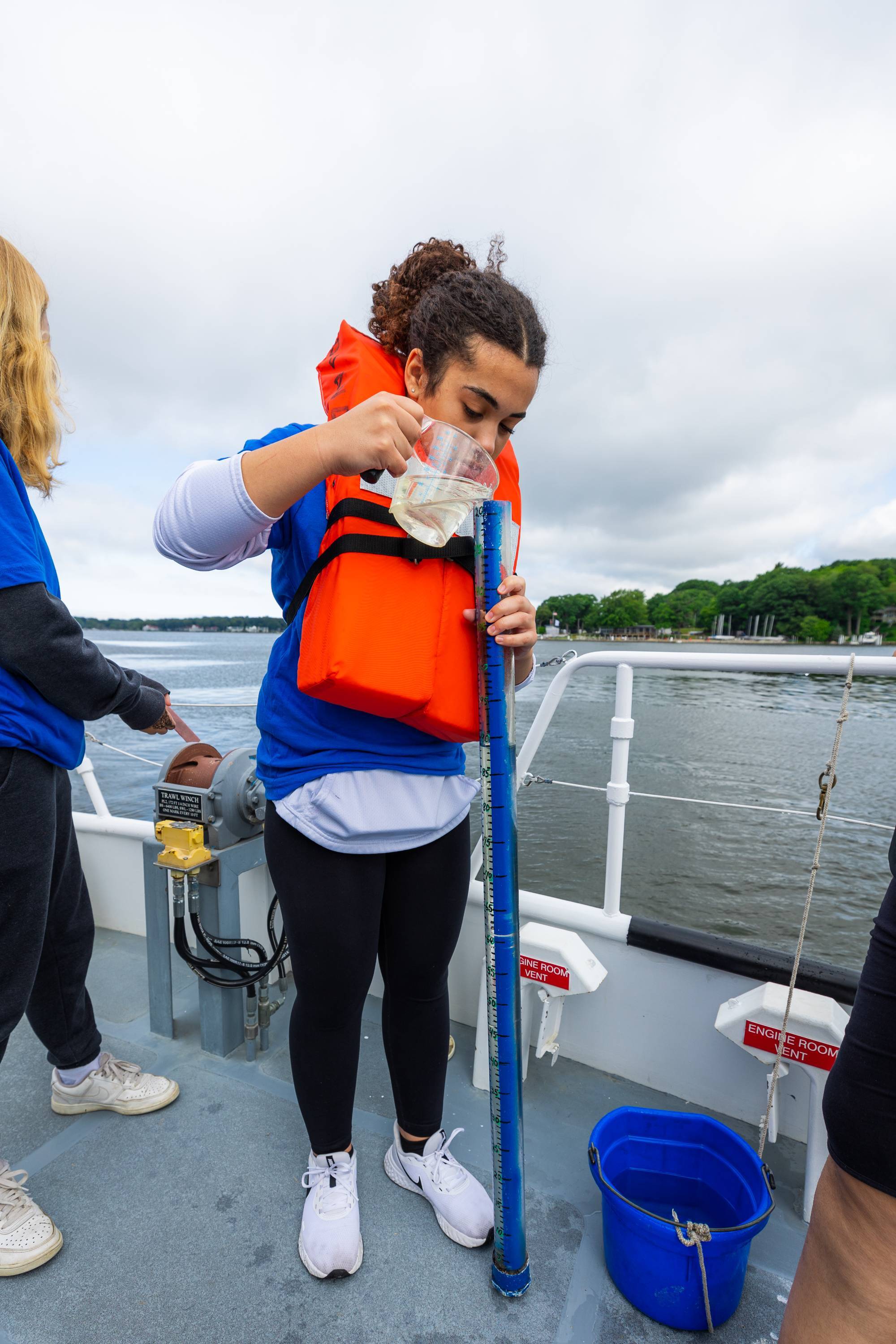 A student onboard the D.J. Angus research vessel conducts a test with a turbidity tube